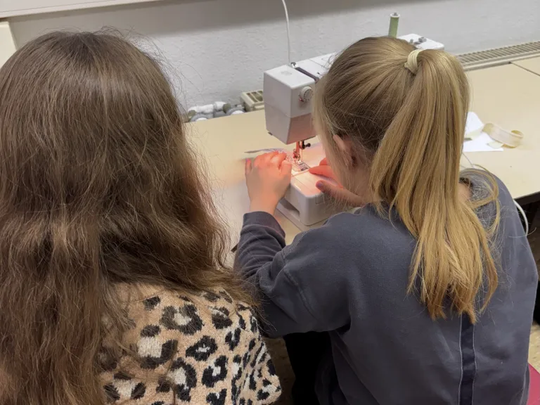 Zwei Mdchen an einer Nhmaschine