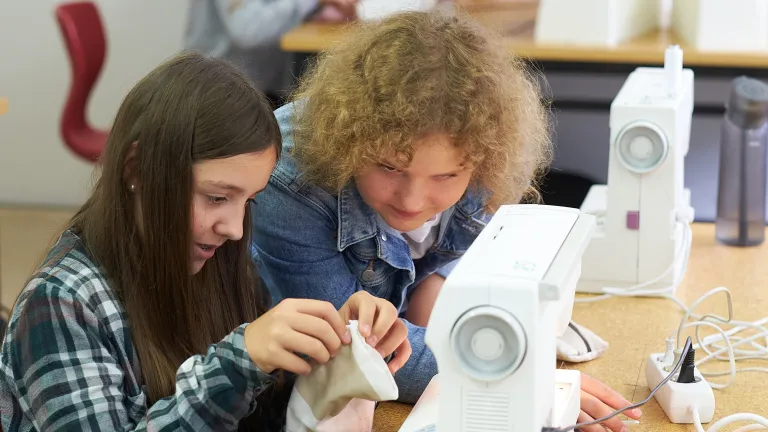 Zwei Schülerinnen an der Nähmaschine