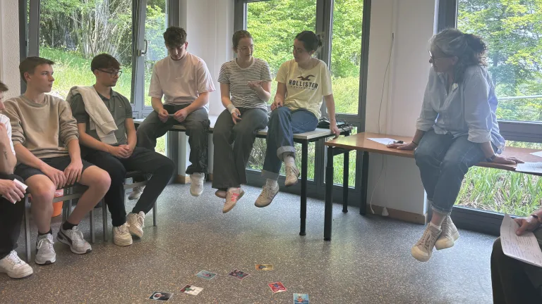 Mdchen luft auf Stangen, die von Mitschlern gehalten werden