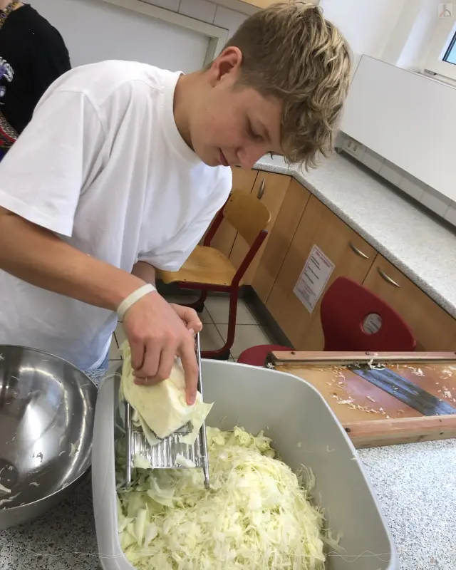 Junge hobelt Sauerkraut