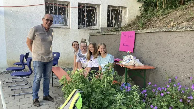 Herr Eisen mit Sch�lerinnen vor Bl�mchen