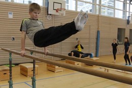 Schüler turnt am Barren